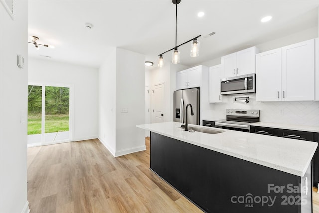 2043 Greenoak Dr, Shelby, NC 28152 - kitchen with tasteful backsplash, white cabinets, a sink, stainless steel appliances, and light wood-style flooring