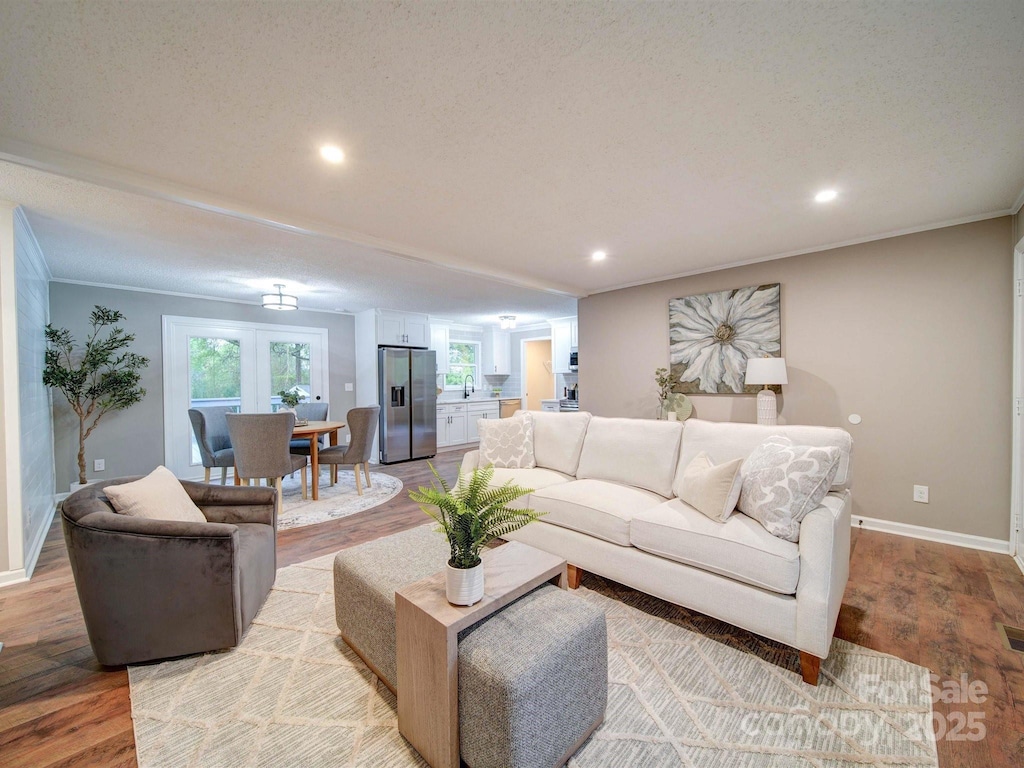 living area with recessed lighting, light wood finished floors, baseboards, and a healthy amount of sunlight