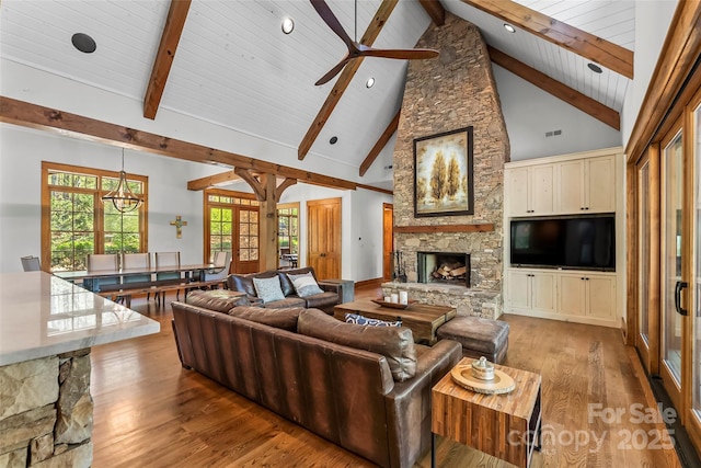 92 Gobblers Neck Dr, Nebo, NC 28761 - living area featuring high vaulted ceiling, beamed ceiling, a ceiling fan, a stone fireplace, and light wood finished floors