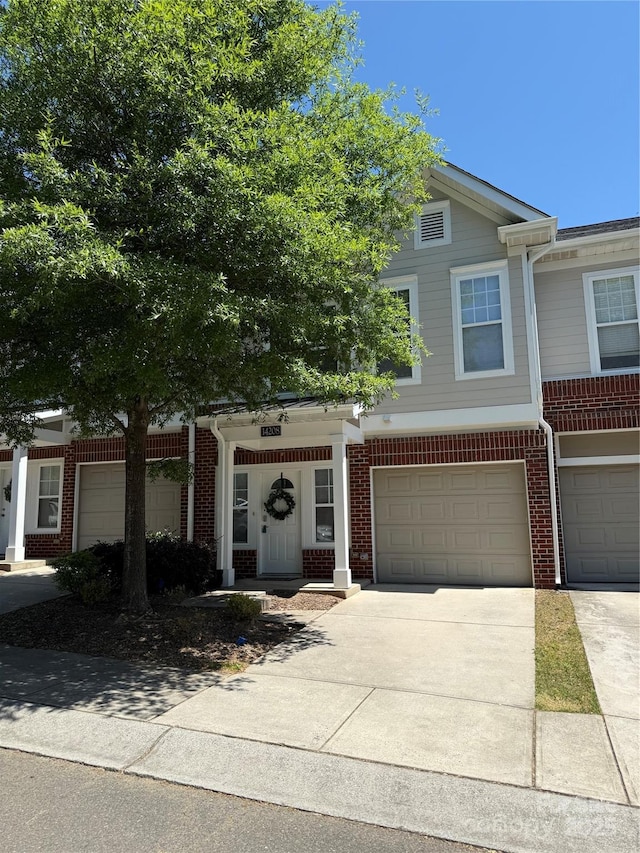 multi unit property featuring brick siding, concrete driveway, and a garage