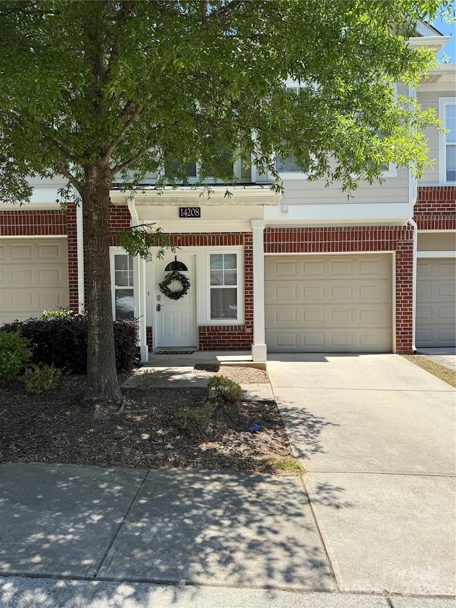 townhome / multi-family property with brick siding and concrete driveway