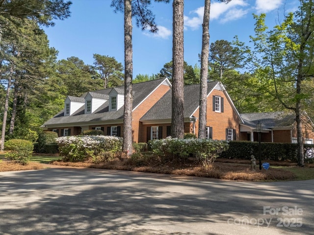 new england style home featuring brick siding