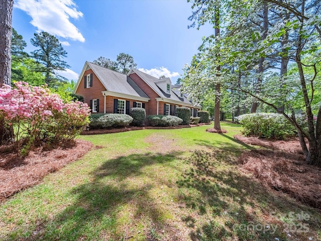 exterior space featuring brick siding and a lawn