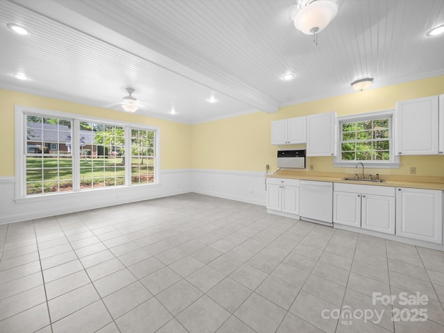 kitchen with a sink, ornamental molding, and dishwasher