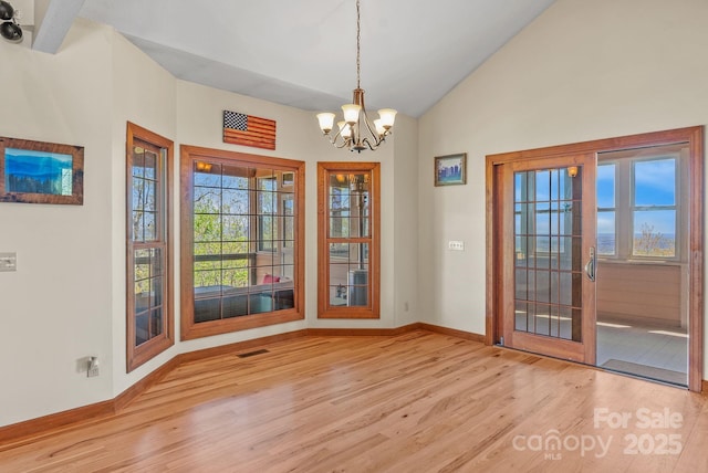 498 Pinnacle Pkwy, Union Mills, NC 28167 - unfurnished dining area with baseboards, vaulted ceiling, a chandelier, visible vents, and wood finished floors