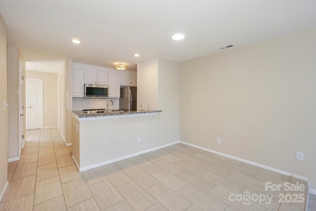 368 NW Dr, Davidson, NC 28036 - kitchen featuring dark stone countertops, visible vents, white cabinetry, recessed lighting, and stainless steel appliances