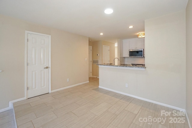 368 NW Dr, Davidson, NC 28036 - kitchen with backsplash, stainless steel microwave, recessed lighting, and baseboards