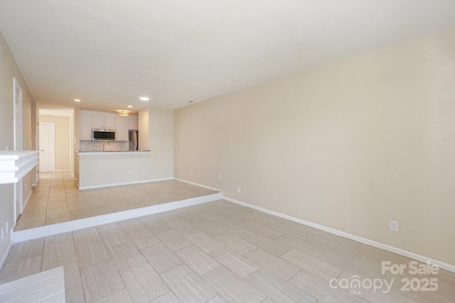 368 NW Dr, Davidson, NC 28036 - unfurnished living room with a sink, baseboards, and recessed lighting