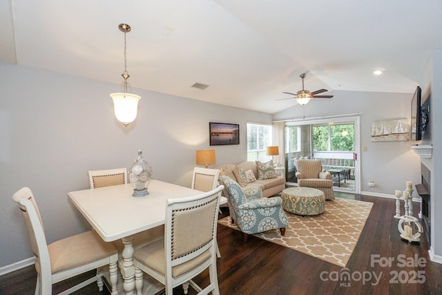 765 SW Dr, Davidson, NC 28036 - dining room featuring baseboards, ceiling fan, a fireplace, dark wood-type flooring, and lofted ceiling