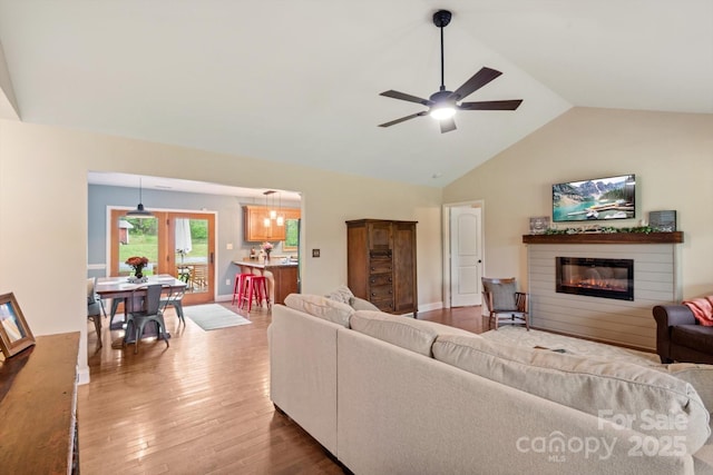 1091 Bill Collins Rd, Columbus, NC 28722 - living room featuring lofted ceiling, wood finished floors, a glass covered fireplace, and ceiling fan