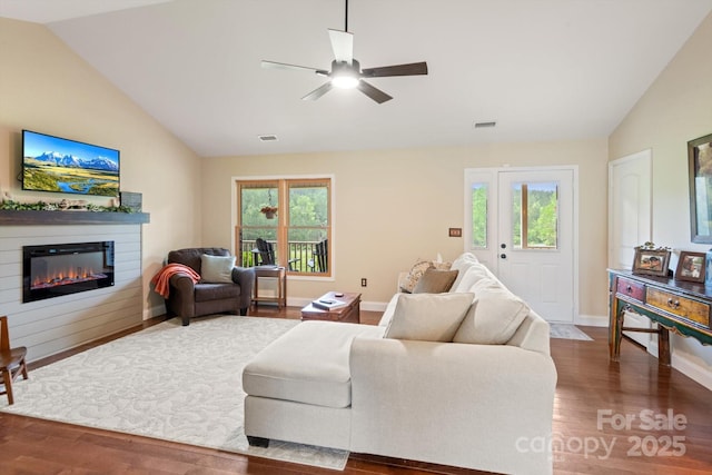 1091 Bill Collins Rd, Columbus, NC 28722 - living room with vaulted ceiling, wood finished floors, healthy amount of natural light, a glass covered fireplace, and a ceiling fan