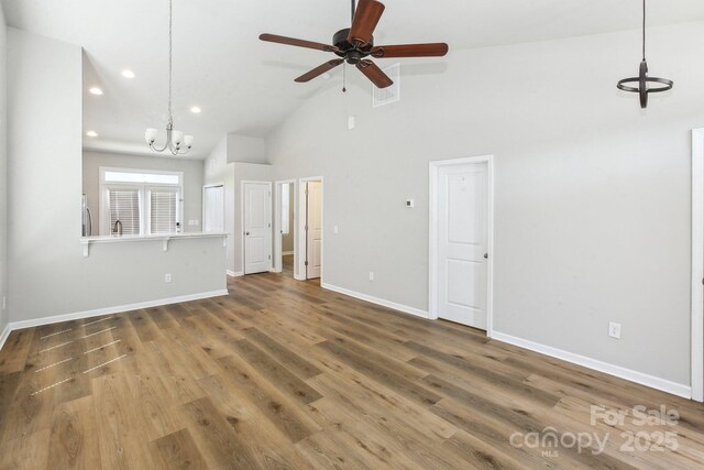 101 N Ferncliff Dr, Mount Holly, NC 28120 - unfurnished living room with ceiling fan with notable chandelier, high vaulted ceiling, recessed lighting, wood finished floors, and baseboards
