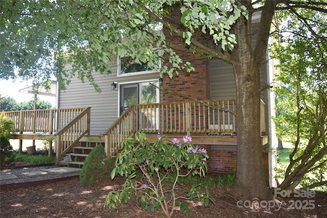 back of house featuring a wooden deck and stairway
