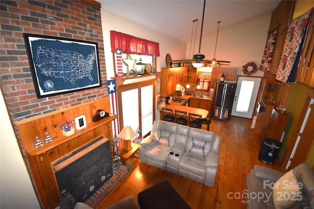 living area featuring bar area, ceiling fan, and wood finished floors
