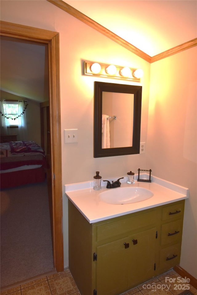 bathroom with vanity, ornamental molding, and vaulted ceiling