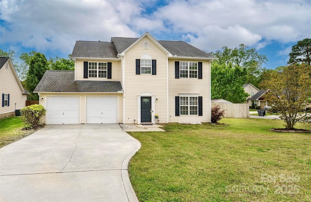 traditional-style house featuring roof with shingles, driveway, a front yard, and a garage