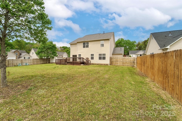 back of property featuring a wooden deck, a yard, and a fenced backyard