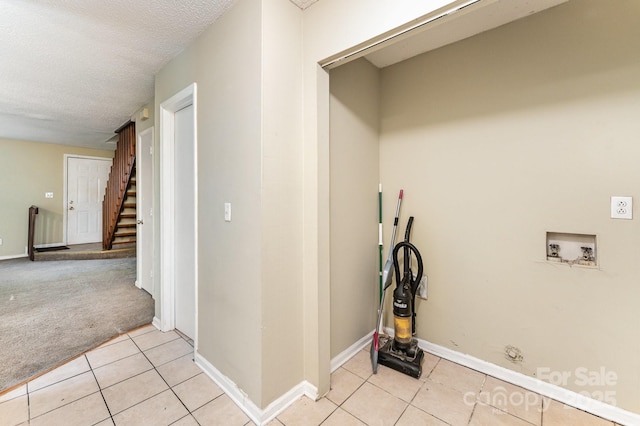 clothes washing area featuring light tile patterned floors, baseboards, washer hookup, a textured ceiling, and light carpet