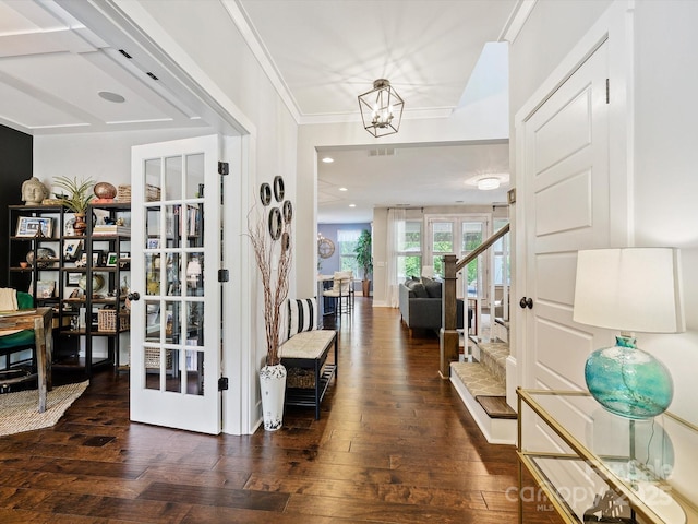 foyer featuring french doors, crown molding, a notable chandelier, and wood-type flooring
