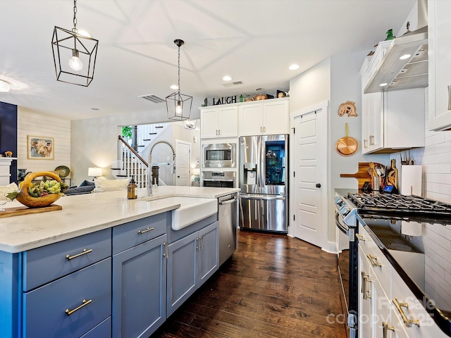 kitchen featuring recessed lighting, a sink, stainless steel appliances, white cabinets, and dark wood finished floors