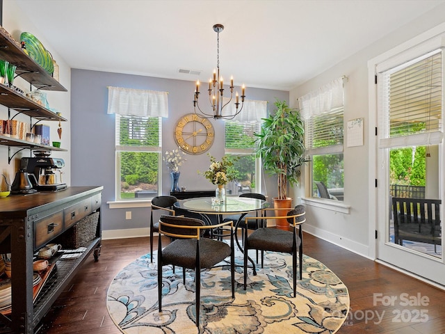 dining room featuring plenty of natural light, an inviting chandelier, wood finished floors, and visible vents