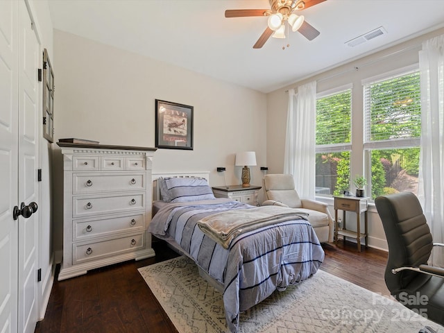 bedroom featuring dark wood-type flooring, visible vents, and a ceiling fan