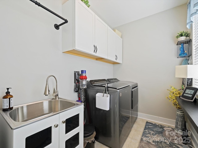 laundry room featuring a sink, independent washer and dryer, cabinet space, and baseboards
