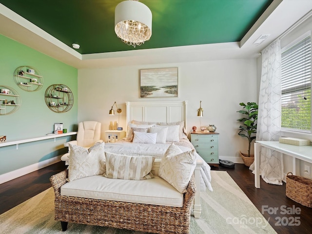 bedroom with dark wood-style flooring, a raised ceiling, baseboards, and multiple windows