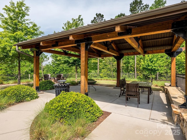 surrounding community featuring fence, outdoor dining space, a gazebo, and a patio area