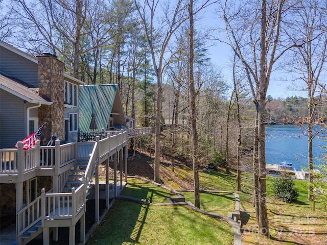 view of yard with a deck with water view and stairway