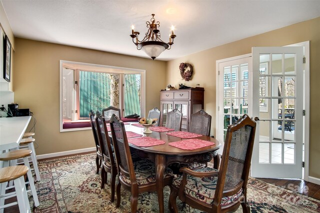 dining room with a chandelier, wood finished floors, and baseboards