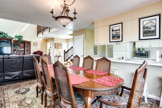 dining space with an inviting chandelier and stairway