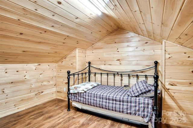 bedroom featuring wooden walls, wood ceiling, vaulted ceiling, and wood finished floors