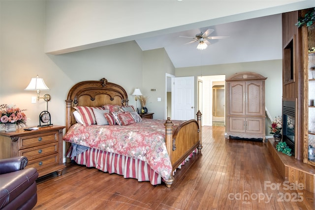bedroom with dark wood-type flooring, high vaulted ceiling, and a ceiling fan