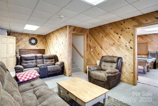 living area with stairway, wooden walls, and carpet floors