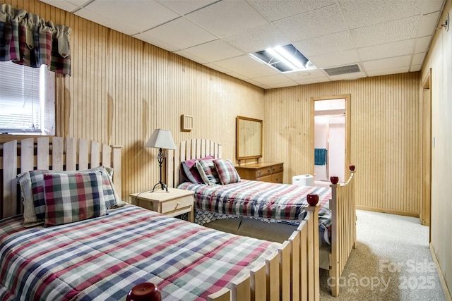 carpeted bedroom featuring a paneled ceiling and visible vents