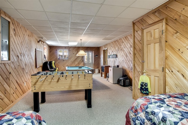 recreation room with electric panel, carpet flooring, a paneled ceiling, and wooden walls