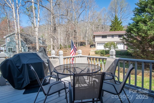 wooden deck with outdoor dining area and grilling area
