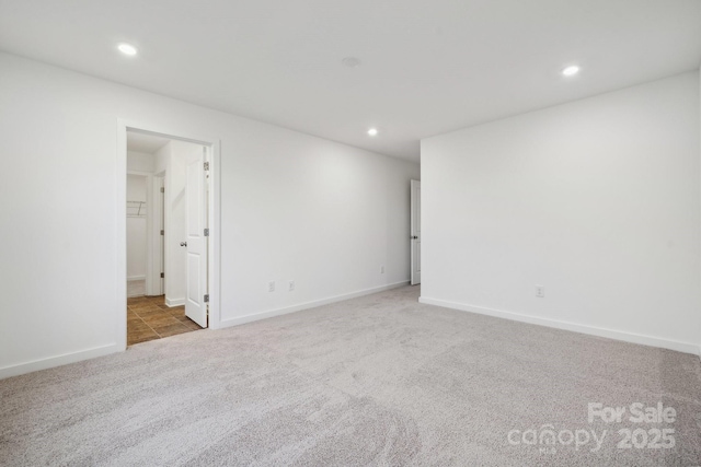 carpeted empty room featuring recessed lighting and baseboards