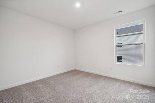 empty room with light colored carpet, baseboards, and visible vents