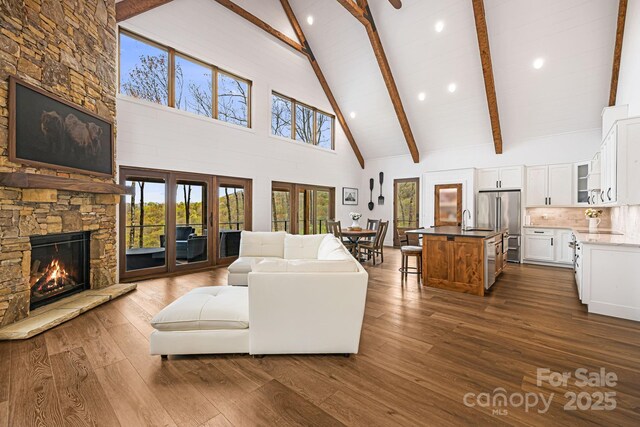 living area with high vaulted ceiling, a fireplace, dark wood finished floors, beamed ceiling, and recessed lighting