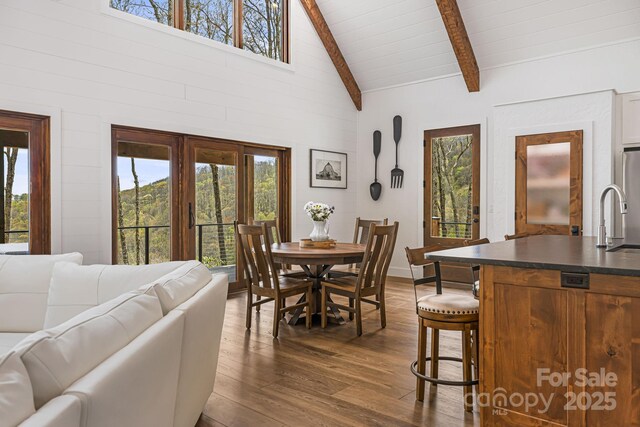 dining space featuring wooden ceiling, dark wood-style flooring, beamed ceiling, and high vaulted ceiling