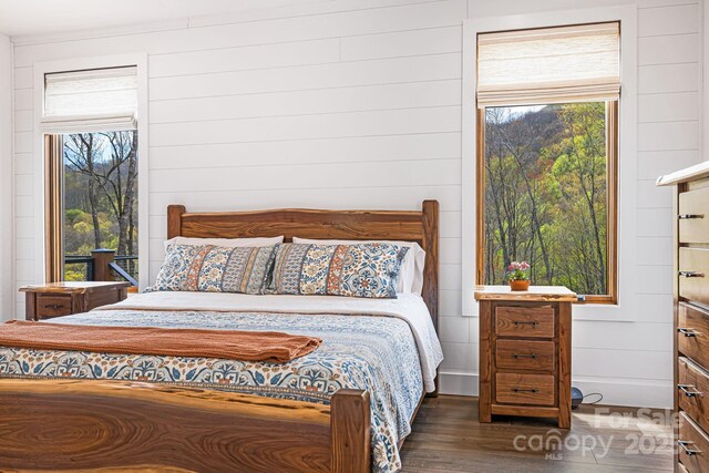 bedroom featuring wooden walls and wood finished floors