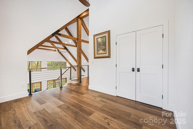 bonus room featuring baseboards, high vaulted ceiling, and wood finished floors