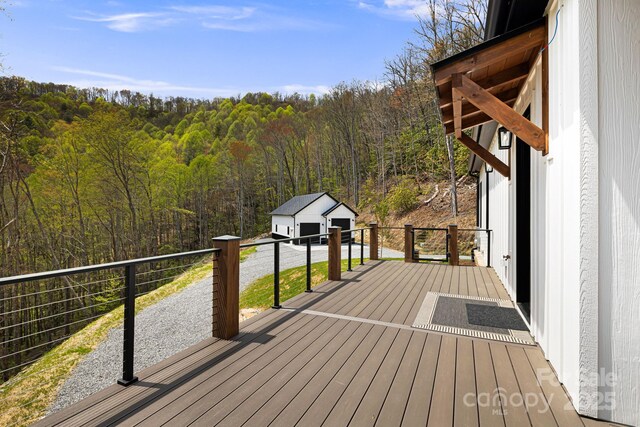 deck with an outbuilding and a forest view
