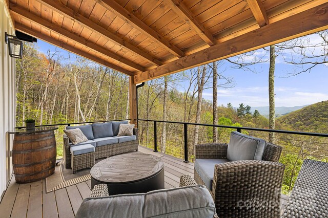 deck with outdoor lounge area and a forest view
