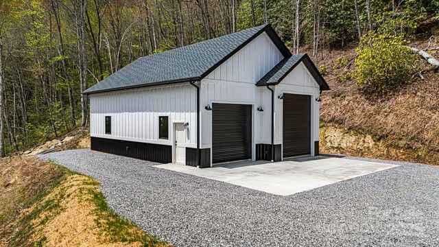 detached garage featuring a forest view