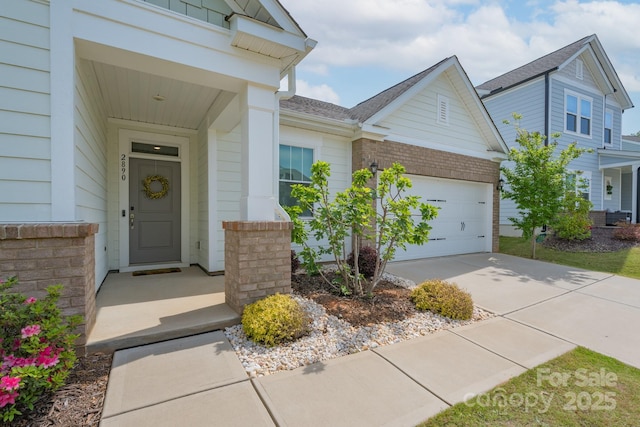 entrance to property with driveway, roof with shingles, brick siding, and an attached garage