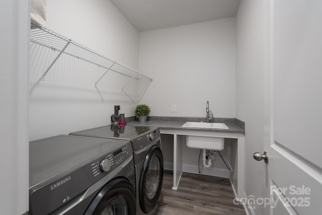 laundry room with a sink, separate washer and dryer, laundry area, baseboards, and wood finished floors