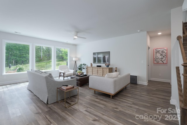 living area with baseboards, visible vents, wood finished floors, and ceiling fan